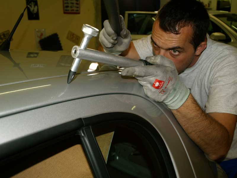 Lackierfreie Beulenreparatur am Fahrzeugdach durch Aebi Drücktechnik